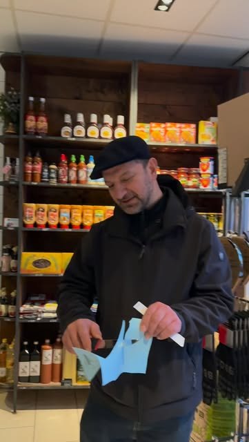 De slager bij de schappen met sauzen en kruiden